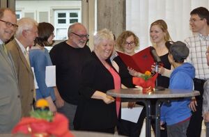 Projektkoordinatorin Lisa von Berg hält die Auszeichnung in Händen